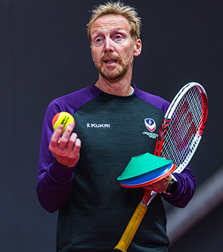 tennis coach, david boddy holding tennis racket and ball